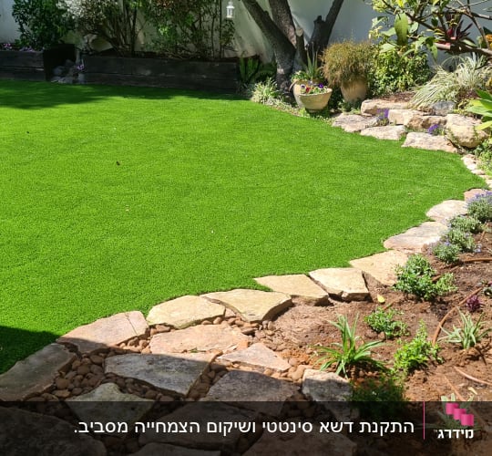 גינה עם דשא סינתטי, שביל אבנים וצמחים צעירים